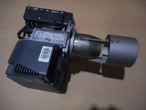 Brenner von Remeha, mit einem kompakten Design, Metallgehäuse und Auslassrohr. Sichtbare Anschlussklemmen und mögliche Hinweise auf elektrische Spezifikationen.